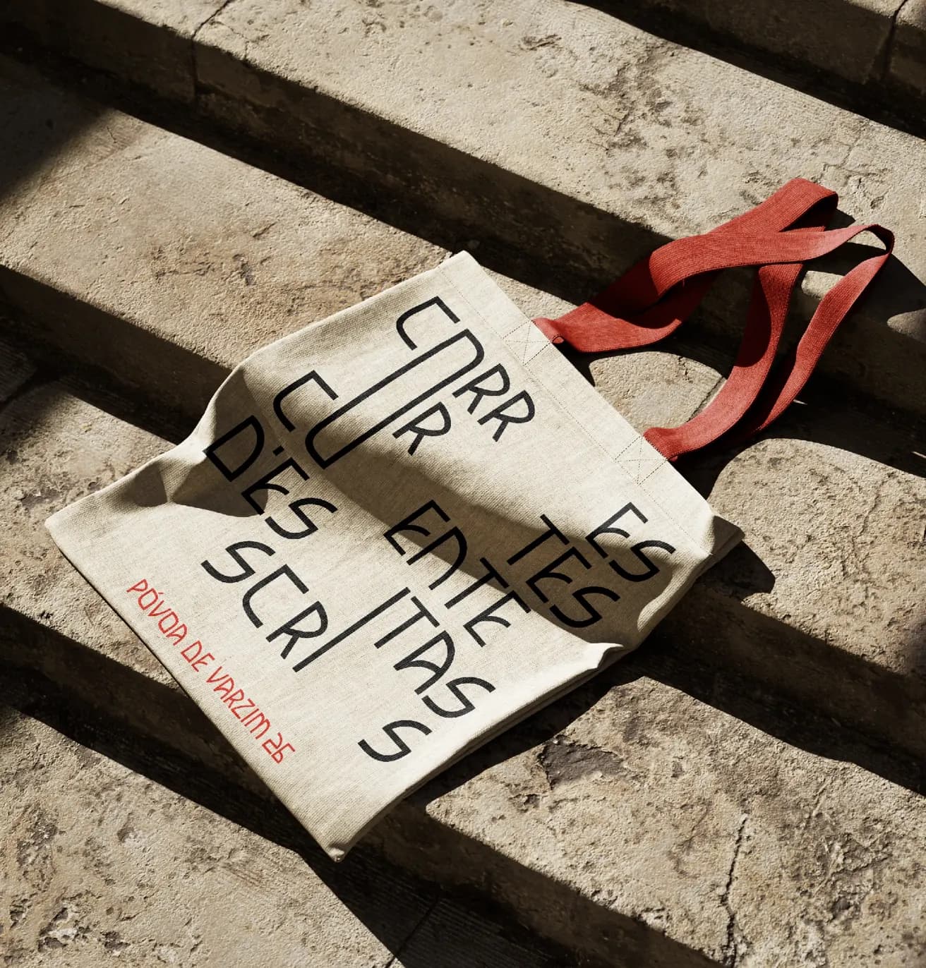 A tote bag printed with the identity, dropped on stone steps