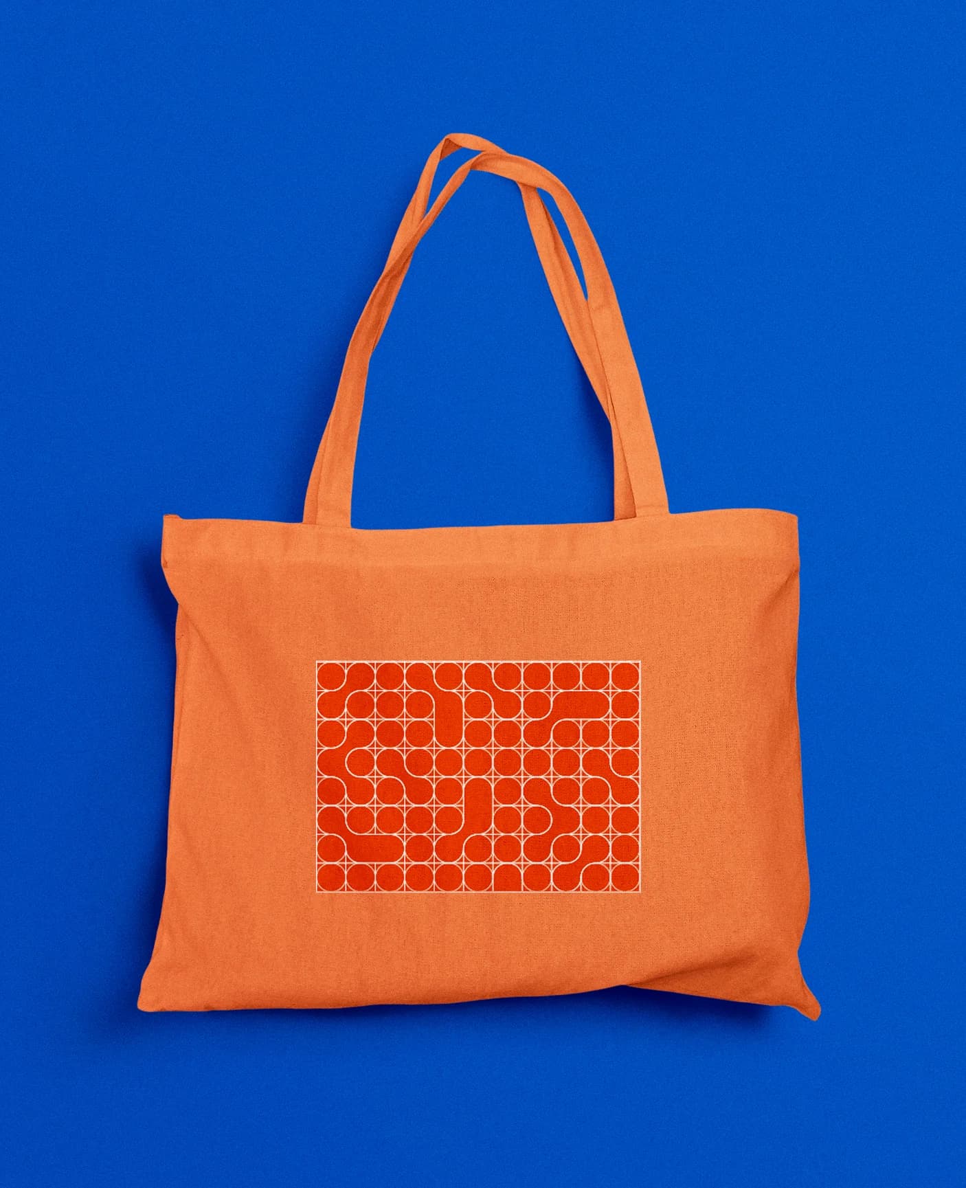 An orange tote printed with the pattern, on blue